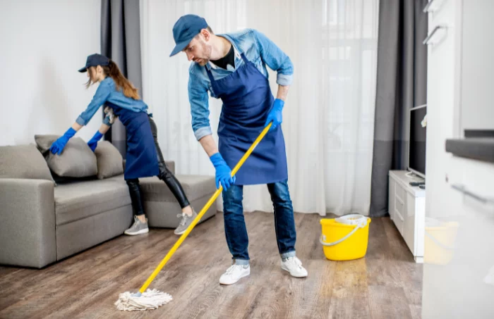 A team of individuals using cleaning equipment to clean the floor surface.